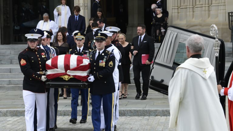 The coffin of Senator John McCain, followed by family members, is carried out of Washington National Cathedral in Washington , on Saturday.