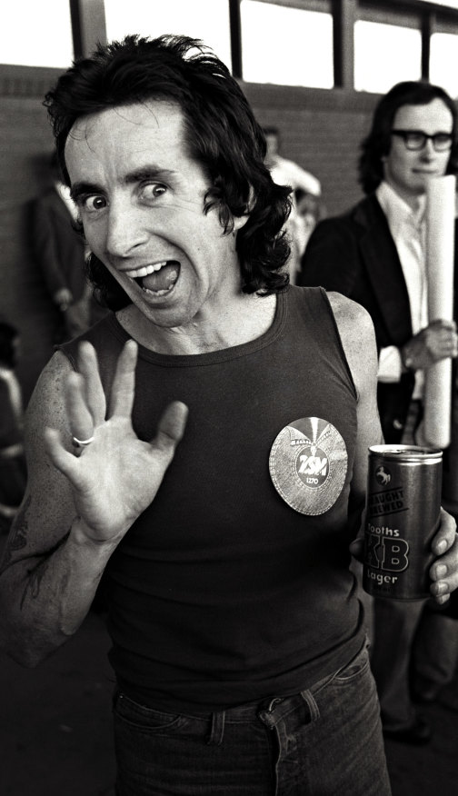 Bon Scott waves to the cameras in 1976 after an overseas tour. 