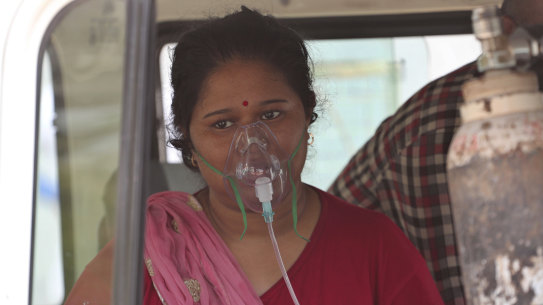 A COVID-19 patient wearing oxygen mask waits to be admitted to a dedicated COVID-19 government hospital in Ahmedabad, India.