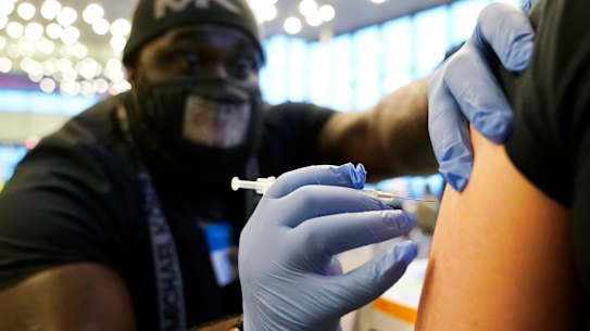 Nurse DeMarcus Hicks delivers a COVID-19 booster shot in Washington.