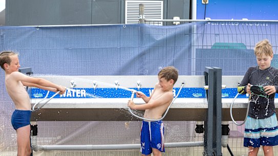 Henry, 10, e Toby, 7, McGarry, de Faulconbridge, descem com mangueira depois de nadar em Penrith Beach em um dia escaldante no início de dezembro.