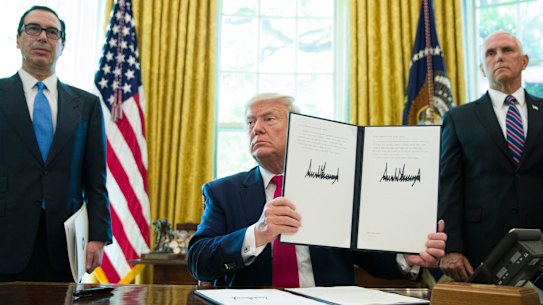 President Donald Trump holds up a signed executive order to increase sanctions on Iran.