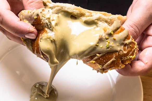 The pistachio cream-filled hot cross bun at Pasticceria Papa in Five Dock.