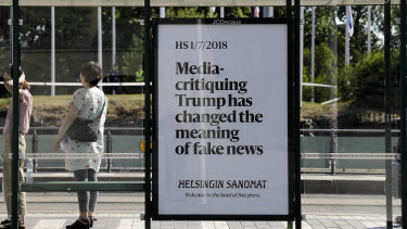 A poster reading 'Media-critiquing Trump has changed the meaning of fake news' is displayed by Finnish newspaper Helsingin Sanomat at a stop for public transport in Helsinki, in July.