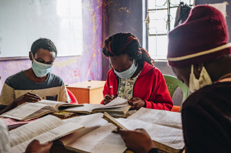 Esther Adhiambo, 18, centre, who will have to start over her senior year of high school, joins other students study in a review class at a community centre in Nairobi, Kenya.