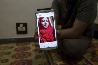 Shahid Nazir Bhat, a Muslim, displays a photograph of Manmeet Kour Bali, a Sikh by birth who converted to Islam to marry him, in Srinagar, India.
