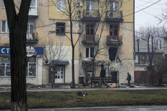 A man walks past an apartment building hit by shelling in Mariupol, Ukraine.