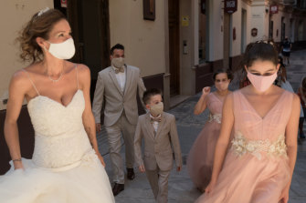 Masked newlyweds and their wedding party in Malaga, Spain.