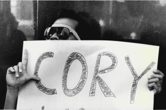 A Filipino protester carries a sign supporting Corazon Aquino. 