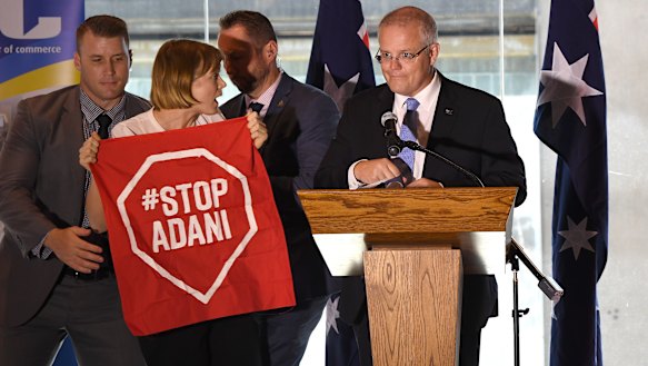 A Stop Adani protester takes to the stage where Australian Prime Minister Scott Morrison was making a speech at a the Valley Chamber of Commerce business luncheon in Brisbane on Monday.