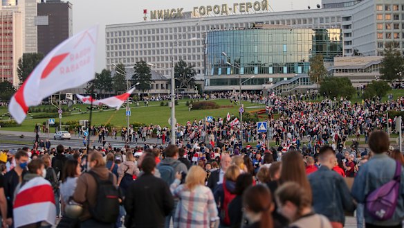 People fly the old Belarusian national flag during a rally to protest against the presidential inauguration.