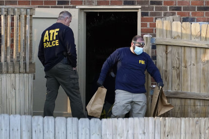 Investigators remove items from the basement of Warner's home on Saturday.