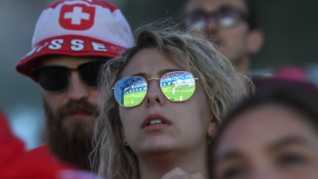Reflected glory: A Swiss fan watches on as Switzerland and Serbia battle in a Group E qualifier.