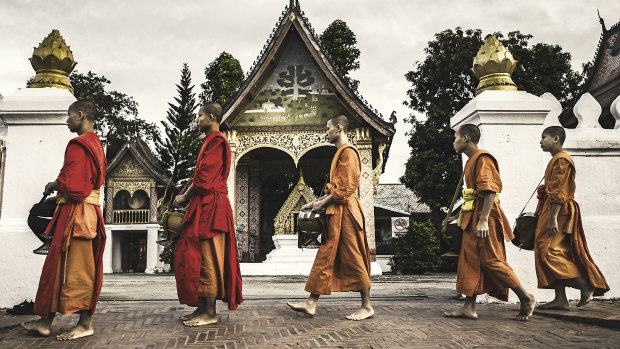 Buddhist monks line up to collect alms in Luang Prabang.