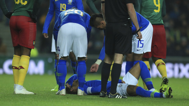 Down and out: Brazil's Neymar lays on the pitch after getting injured during a friendly with Cameroon.