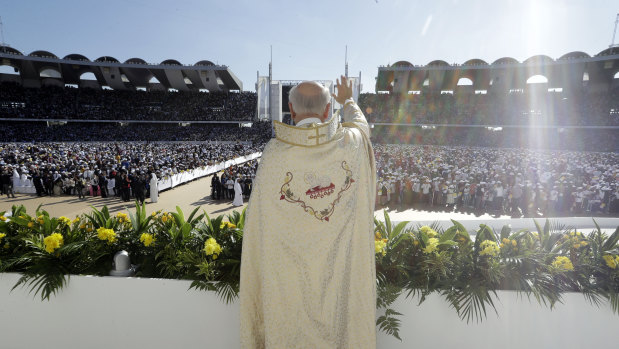 A priest waves to the crowd at Sheikh Zayed Stadium in Abu Dhabi during the UAE's first-ever papal Mass in February.