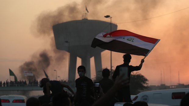 Anti-government protesters wave flags during a demonstration in Baghdad, Iraq.