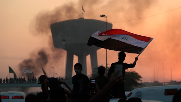 Anti-government protesters wave flags during a demonstration in Baghdad, Iraq.