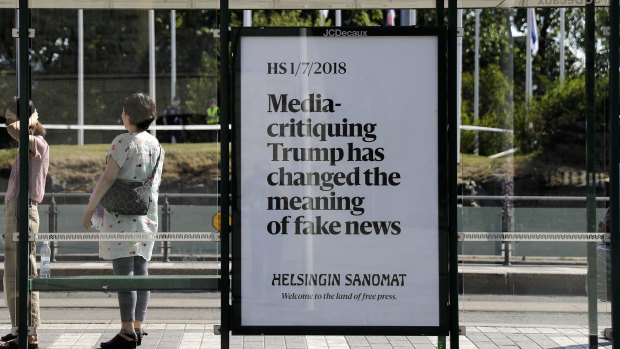 A poster reading 'Media-critiquing Trump has changed the meaning of fake news' is displayed by Finnish newspaper Helsingin Sanomat at a stop for public transport in Helsinki, in July.