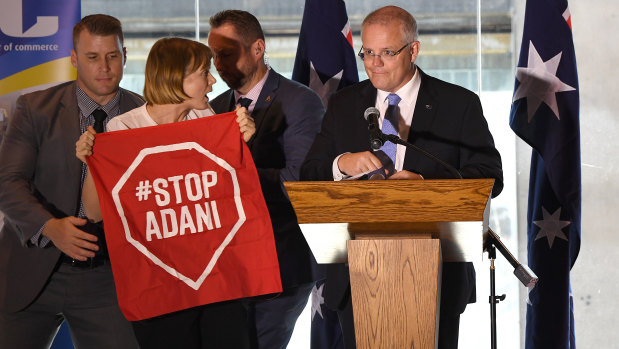 A Stop Adani protester takes to the stage where Australian Prime Minister Scott Morrison was making a speech at a the Valley Chamber of Commerce business luncheon in Brisbane on Monday.