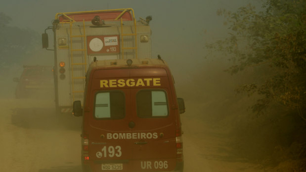 Firefighters advance through smoke near the National Forest of Jacunda in Rondonia state, part of Brazil's Amazon.