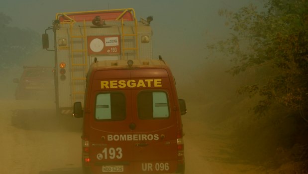 Firefighters advance through smoke near the National Forest of Jacunda in Rondonia state, part of Brazil's Amazon.