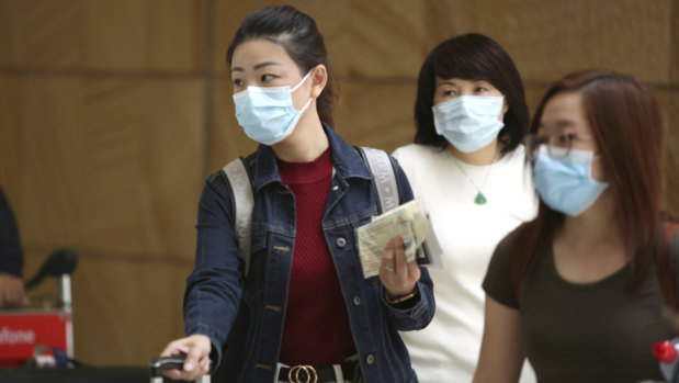 Flight crew and passengers arriving at Sydney International Airport from China on Thursday.