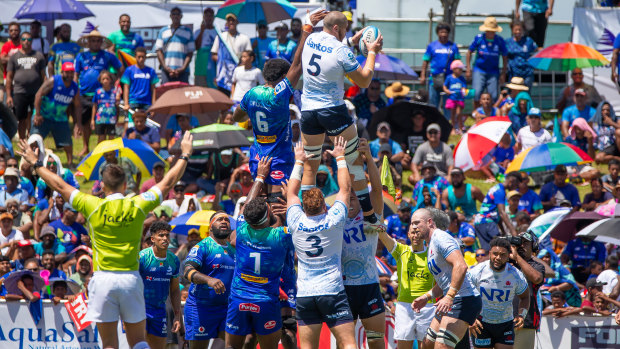 Fergus Lee Warner catches a ball at a lineout as the Fijian crowd looks on.