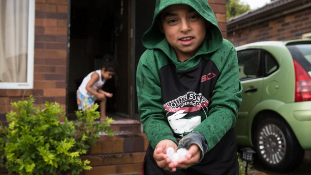 Fadi and Leya Amine collect hail stones in their front yard in Maroubra. 