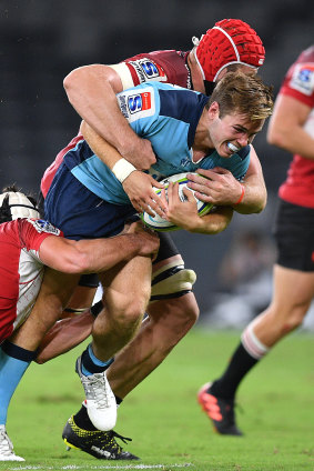 Will Harrison is tackled by Len Massyn at Bankwest Stadium.