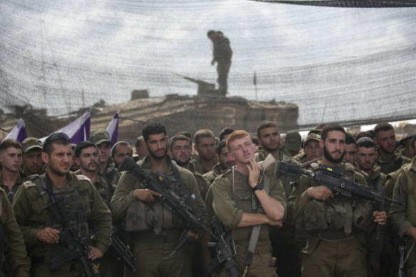 Israeli soldiers wait for a meeting with Defence Minister Yoav Gallant on the border with Gaza.
