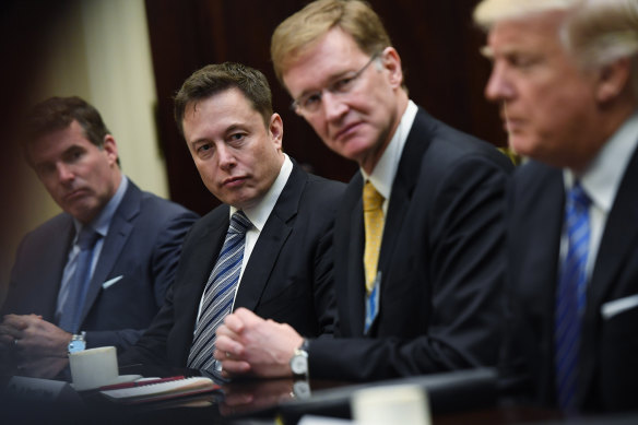 Elon Musk listen to then-president Donald Trump during a meeting with business leaders in 2017.