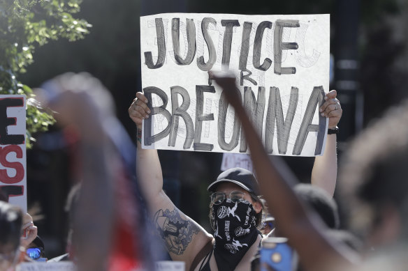 A protester holds a sign during a march over the deaths of George Floyd and Breonna Taylor this month.