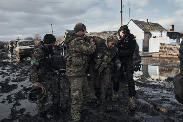 Ukrainian soldiers help a wounded comrade into an evacuation vehicle near the front line in Bakhmut, Donetsk.