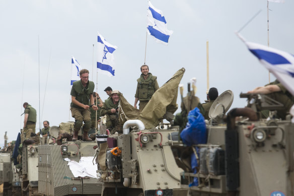 Israeli soldiers stand on armoured personnel carriers near the Israeli border with Lebanon.