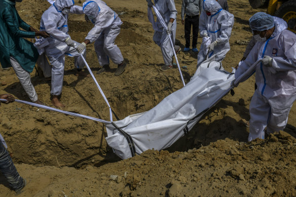 A coronavirus victim’s body is buried at a cemetery in New Delhi.