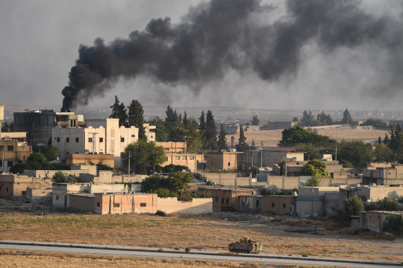 A Turkish army armoured vehicle advances in the Syrian city of Tel Abyad, as seen from the Turkish border town of Akcakale on October 13.