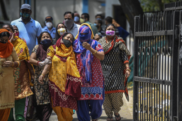 Distraught women outside a hospital where coronavirus cases and deaths are increasing, in New Delhi.