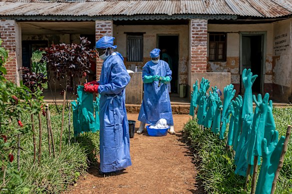 Health workers hang protective gloves to dry after washing them for reuse at Mongbwalu General Hospital.