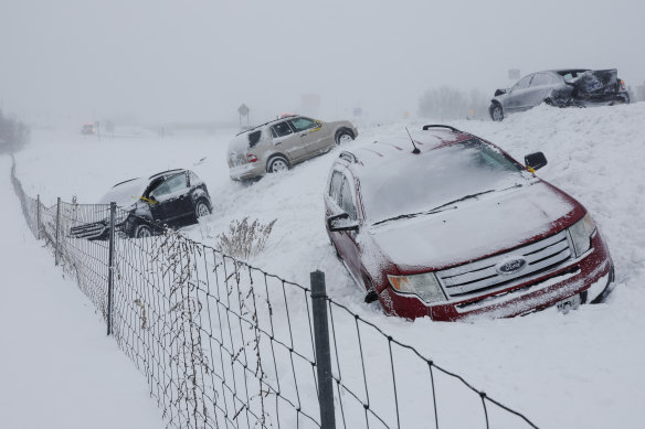In Michigan, a car stops on a road with a blizzard warning. 