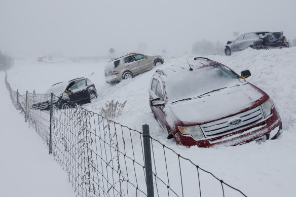 Cars sit by the road with a blizzard warning in place in Michigan. 