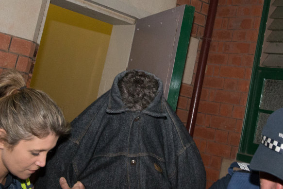 Adrian Basham obscures his face outside Bairnsdale Magistrates Court before a hearing last year.