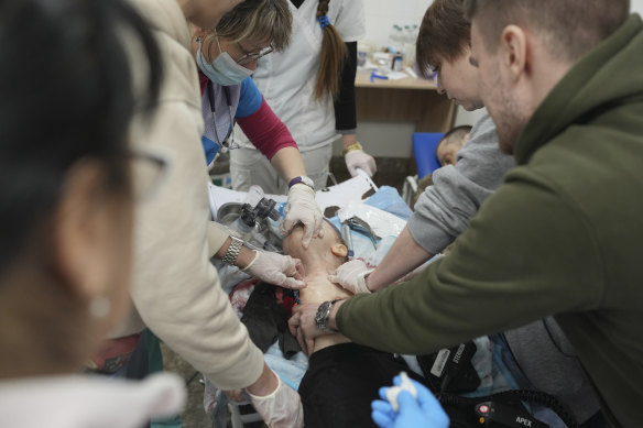 Medics try – unsuccessfully – try to save the life of Marina Yatsko’s 18-month-old son Kirill, who was wounded by shelling in Mariupol on Friday.