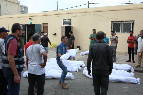 Palestinians prepare the bodies of people killed in overnight airstrikes for burial at the hospital in Deir al-Balah, in the southern Gaza Strip.