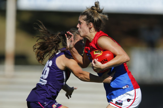 Lauren Pearce, right, of the Demons, fends off a tackle in a Fremantle Dockers clash in March. 