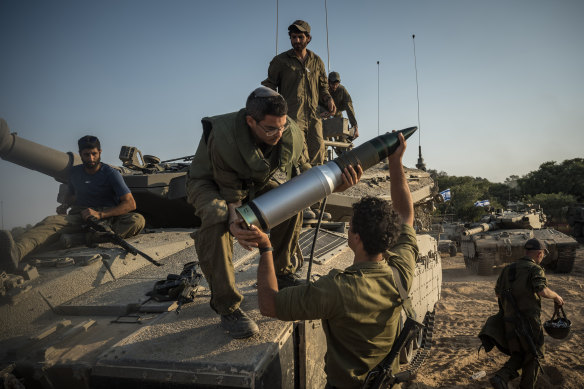 Israeli soldiers load tank shells as their unit massed in Be’eri, near the border with the Gaza Strip on Saturday.