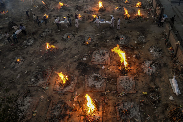 New bodies arrive at a mass cremation site in Delhi, India, April 23, 2021. US government administration officials are coming under increasing pressure to lift restrictions on exports of supplies that vaccine makers in India say they need to expand production amid a devastating surge in COVID-19 deaths there. 