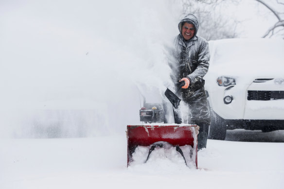 Francisco Erazo uses his snow blower to clear snow in Michigan.