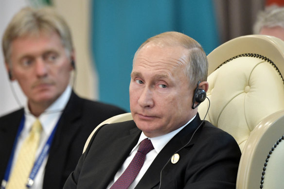 Russian President Vladimir Putin, front, and his spokesman Dmitry Peskov.
