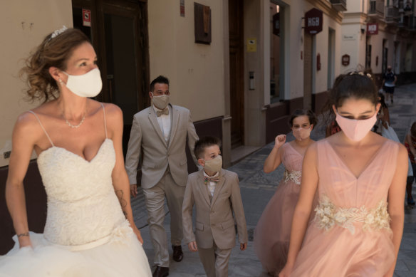 Masked newlyweds and their wedding party in Malaga, Spain.